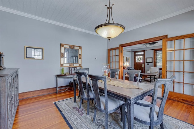 dining room featuring baseboards, crown molding, light wood-style floors, and ceiling fan