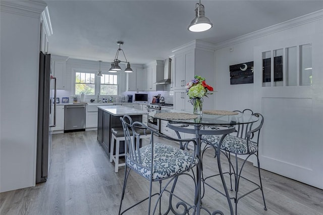 dining space featuring crown molding and light wood-style floors