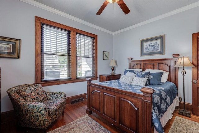bedroom featuring baseboards, visible vents, crown molding, and wood finished floors