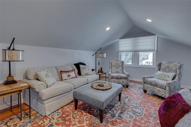 living room with baseboards, lofted ceiling, and wood finished floors