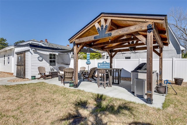 view of patio featuring an outdoor structure, a gazebo, and fence