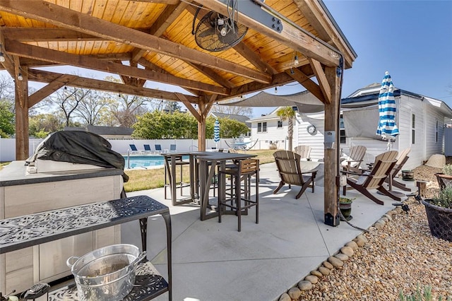 view of patio / terrace featuring a fenced in pool, a gazebo, outdoor dining space, and fence