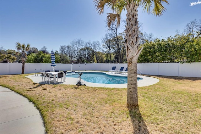 view of swimming pool with a lawn, a fenced in pool, a fenced backyard, and a patio