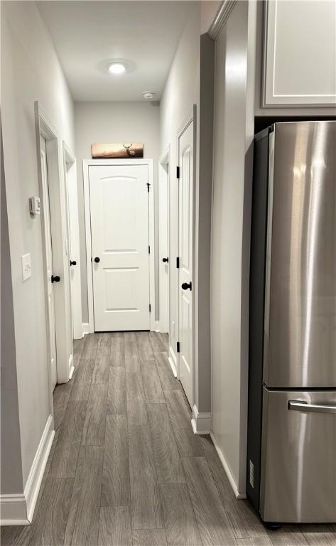 corridor with wood finished floors and baseboards