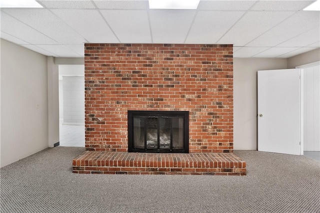 details featuring a drop ceiling, carpet flooring, and a brick fireplace