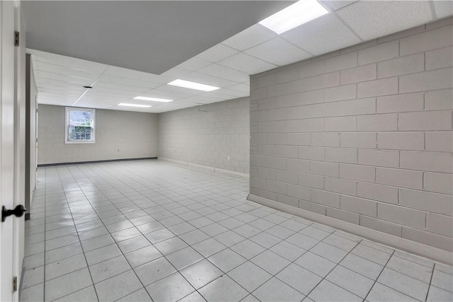 unfurnished room with concrete block wall and a paneled ceiling
