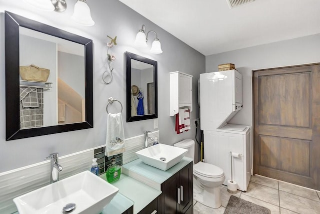 bathroom featuring toilet, a sink, tile patterned floors, and visible vents