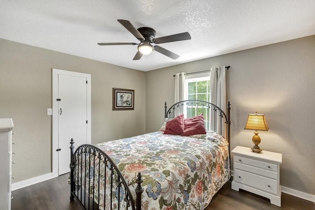 bedroom with baseboards, a textured ceiling, dark wood-style floors, and a ceiling fan
