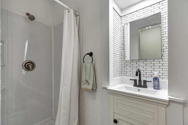 bathroom with a shower with curtain, decorative backsplash, and vanity