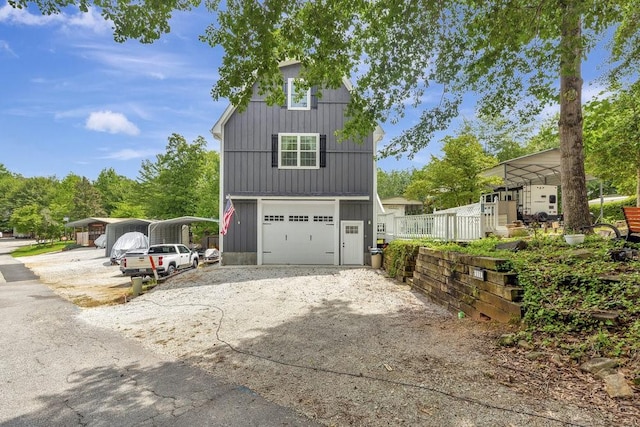 garage featuring driveway and a detached carport
