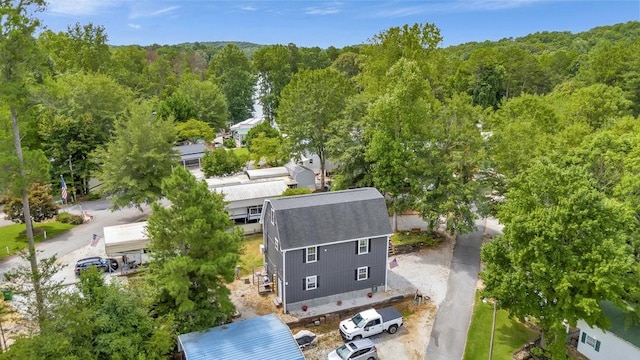 birds eye view of property featuring a forest view