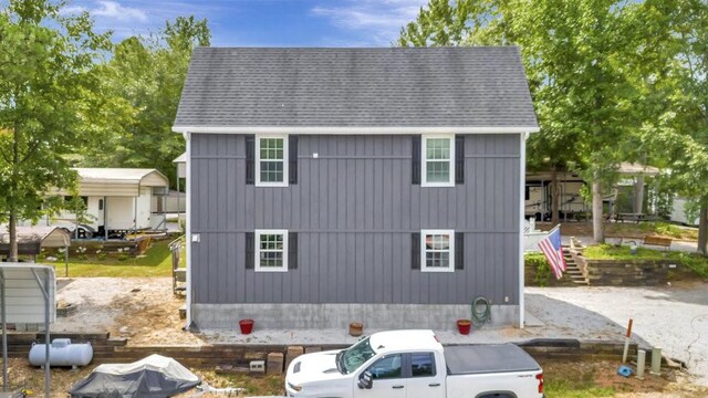 exterior space featuring stairway and roof with shingles