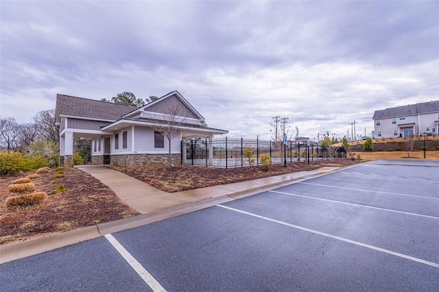 view of home's community featuring uncovered parking and fence
