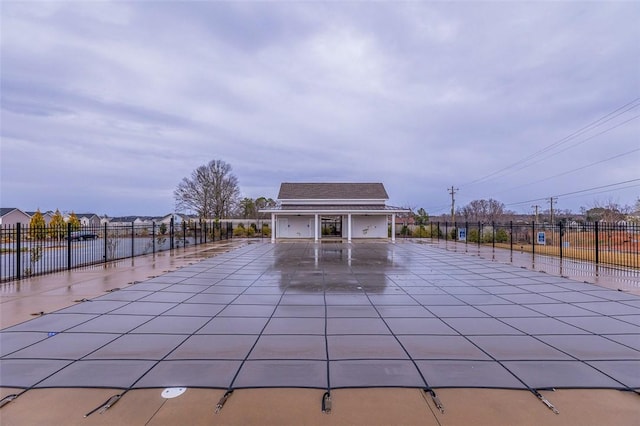 view of community featuring a patio, an outbuilding, fence, and concrete driveway