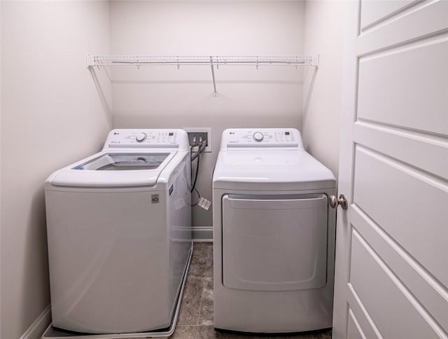 clothes washing area featuring laundry area, baseboards, and separate washer and dryer