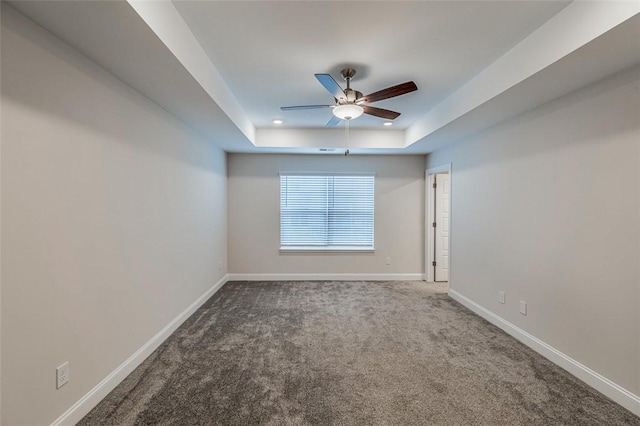 unfurnished room with a tray ceiling, recessed lighting, carpet, baseboards, and a ceiling fan