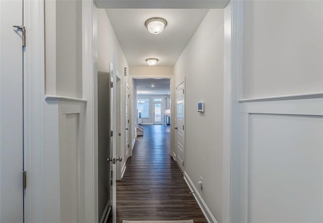 hall featuring baseboards and dark wood finished floors