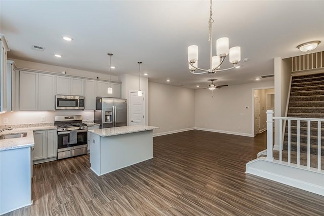 kitchen with a center island, a sink, dark wood-style floors, visible vents, and appliances with stainless steel finishes