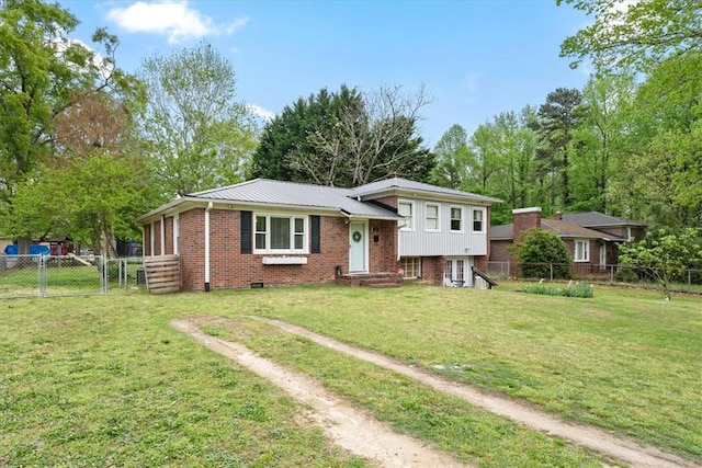 tri-level home with metal roof, fence, brick siding, a front lawn, and a gate