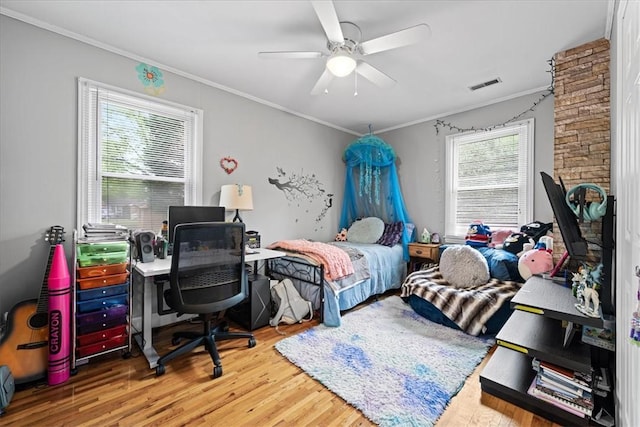 bedroom with crown molding, wood finished floors, and visible vents