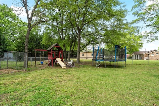 view of yard with a trampoline, a fenced backyard, and a playground