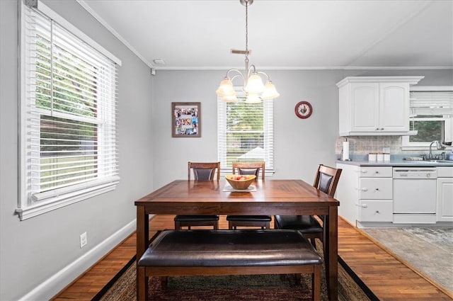 dining area with light wood finished floors, an inviting chandelier, and plenty of natural light