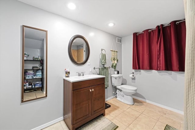 bathroom with visible vents, baseboards, toilet, vanity, and tile patterned flooring