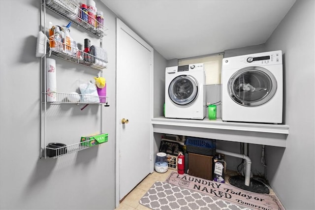 laundry room with light tile patterned floors, laundry area, and washing machine and clothes dryer