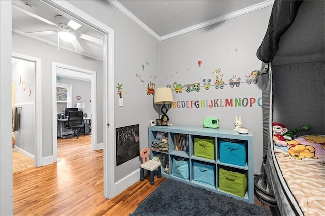 game room with wood finished floors, ceiling fan, baseboards, and ornamental molding