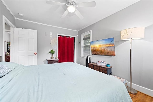 bedroom featuring ornamental molding, baseboards, a ceiling fan, and wood finished floors