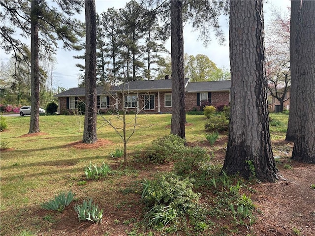 ranch-style home with brick siding and a front yard