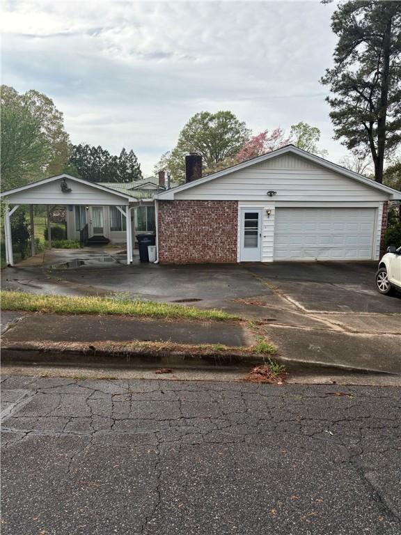 view of front of home with brick siding, a garage, and concrete driveway
