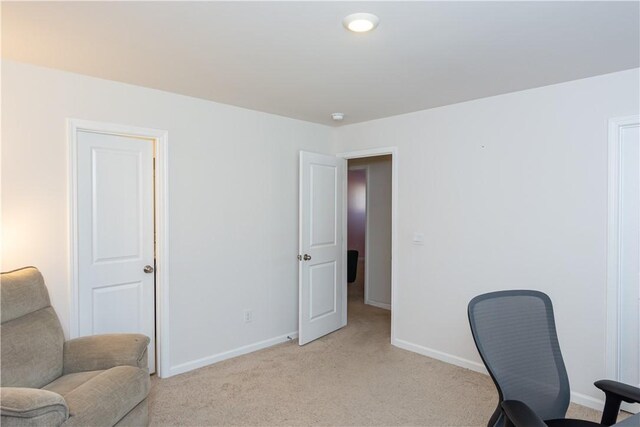 office space featuring light carpet and baseboards