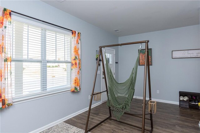 bedroom featuring visible vents, baseboards, and wood finished floors