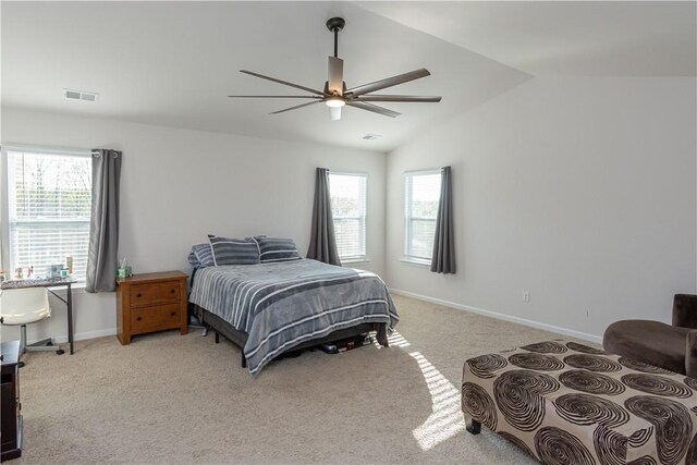 bedroom with vaulted ceiling, visible vents, light colored carpet, and multiple windows