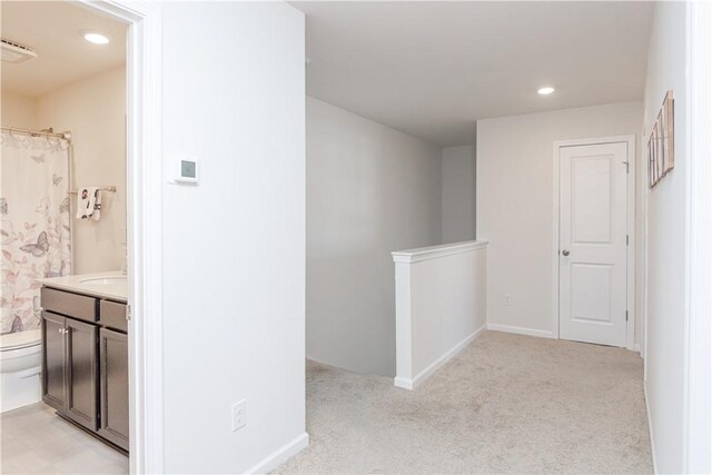 hallway with baseboards, recessed lighting, an upstairs landing, and light colored carpet