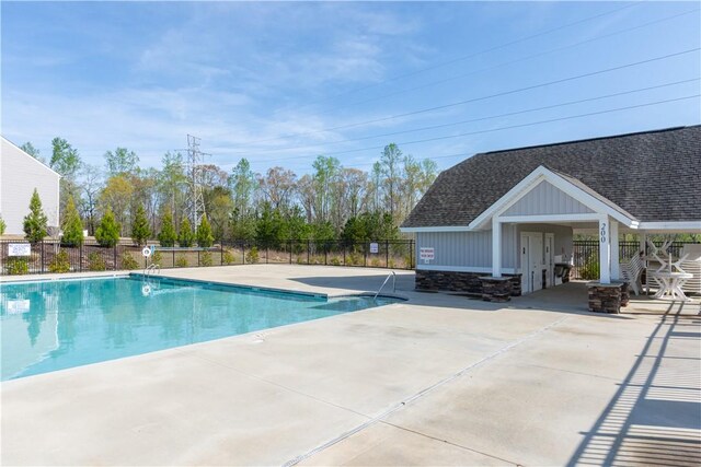 community pool featuring fence and a patio area
