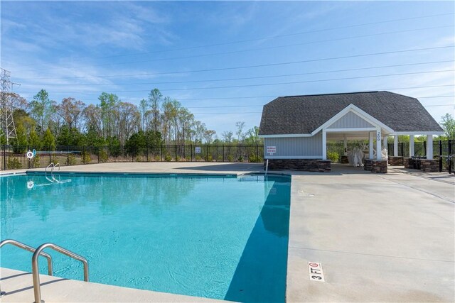 community pool featuring fence and a patio