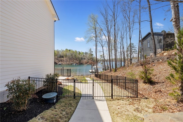 exterior space with a gate, a water view, and fence