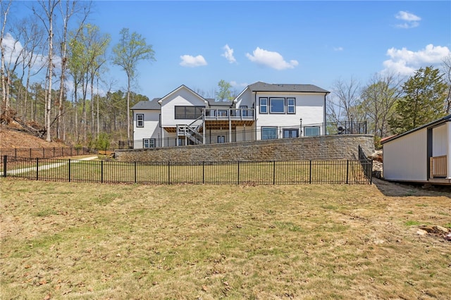 rear view of house with a lawn and fence