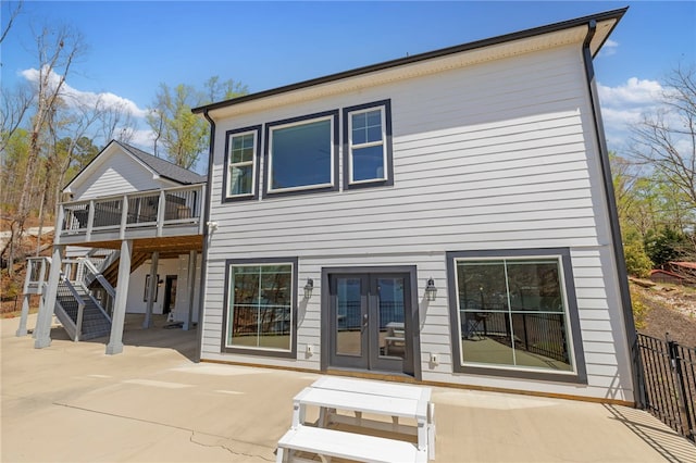 rear view of house featuring french doors, stairway, a deck, and a patio