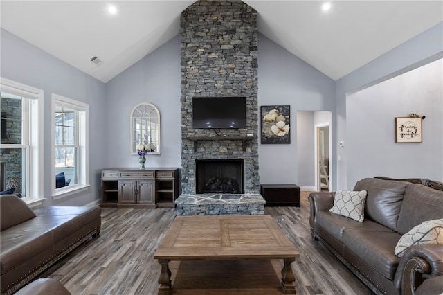 living area featuring baseboards, a fireplace, visible vents, and wood finished floors
