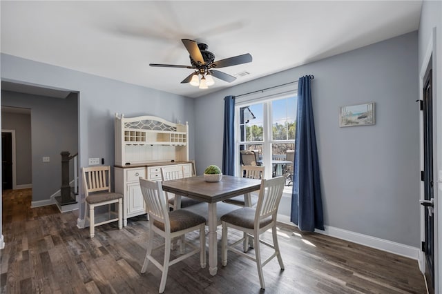 dining space featuring baseboards, visible vents, dark wood-type flooring, and a ceiling fan