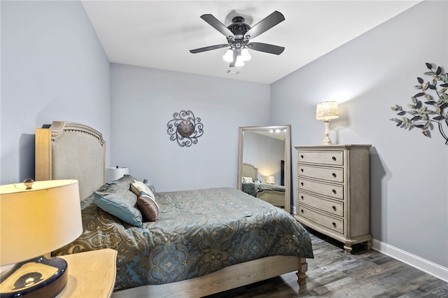 bedroom featuring baseboards, visible vents, wood finished floors, and a ceiling fan