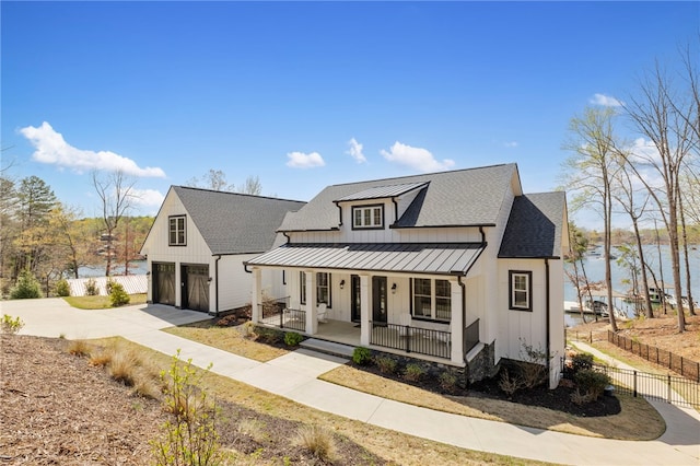 modern farmhouse featuring a standing seam roof, fence, board and batten siding, a porch, and a garage