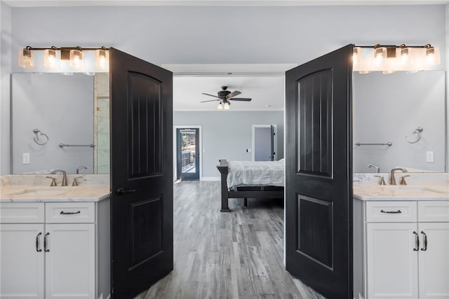 bathroom featuring ceiling fan, a sink, and two vanities