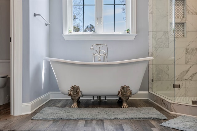 full bath featuring a shower with door, wood finished floors, and a freestanding bath