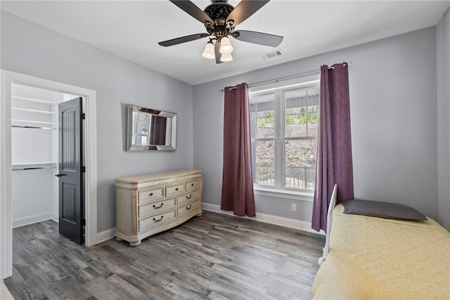 bedroom featuring baseboards, visible vents, wood finished floors, and a ceiling fan