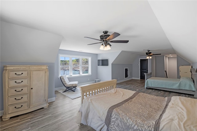 bedroom featuring a ceiling fan, lofted ceiling, baseboards, and light wood finished floors