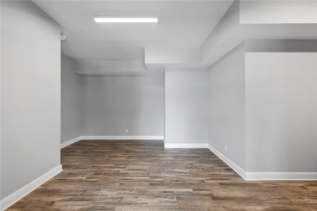 spare room featuring baseboards and wood finished floors